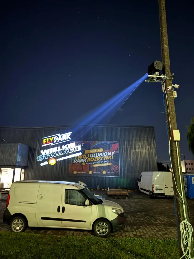 Projekcja logo na elewacji Flypark Kalisz z projektora na maszcie