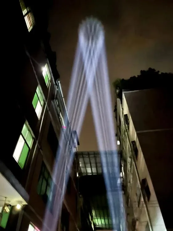 Dalekosiężne snopy światła projektora Skybeam BMO380 nad zabudową po zmroku